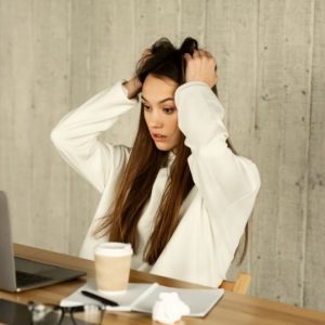 Webdesign Göttingen. Verzweifelte Frau greift sich an den Haarren